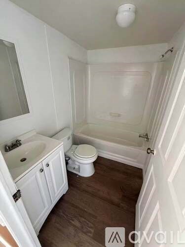 A white bathroom with a toilet, sink, and bathtub.
