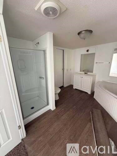 A bathroom with a glass shower door and a white cabinet.