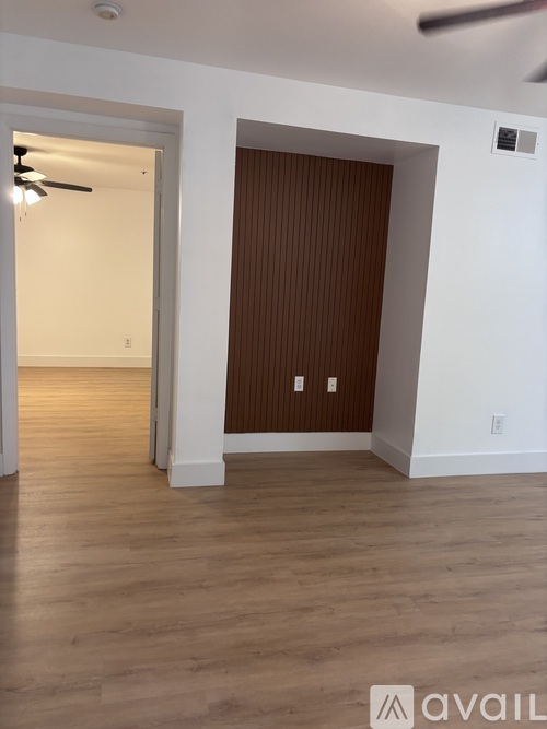 A room with a wooden floor and a brown door.