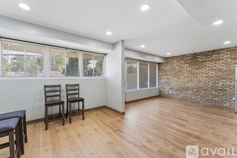 A room with wooden floors and a brick wall.