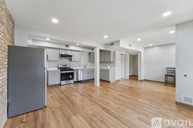 A kitchen with a refrigerator, sink, and cabinets.