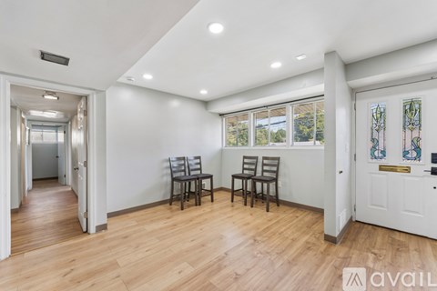 A room with a white door, two chairs and a table.