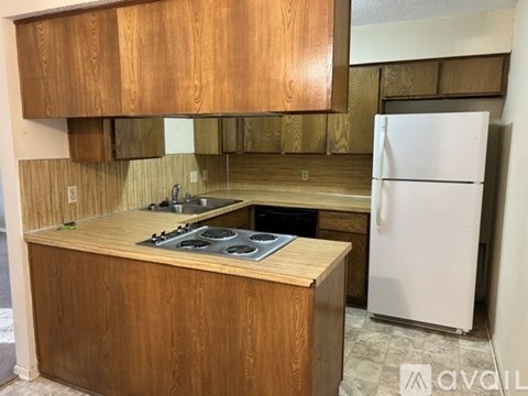 A kitchen with wooden cabinets and a white fridge.