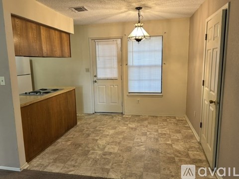 A kitchen area with a refrigerator, cabinets, and a countertop.