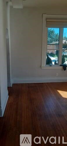 A room with a window and wooden flooring.