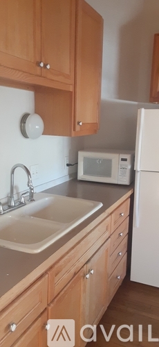 A kitchen with wooden cabinets and a white refrigerator.