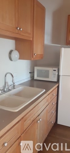 A kitchen with wooden cabinets and a white refrigerator.