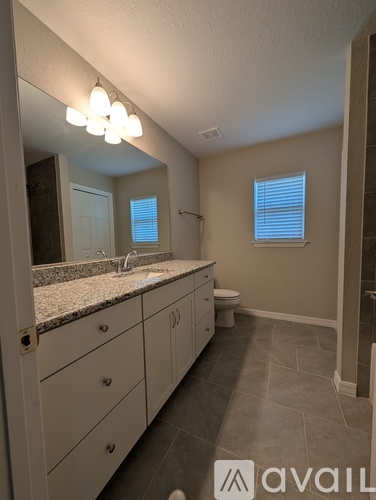 A bathroom with a granite countertop and a sink.