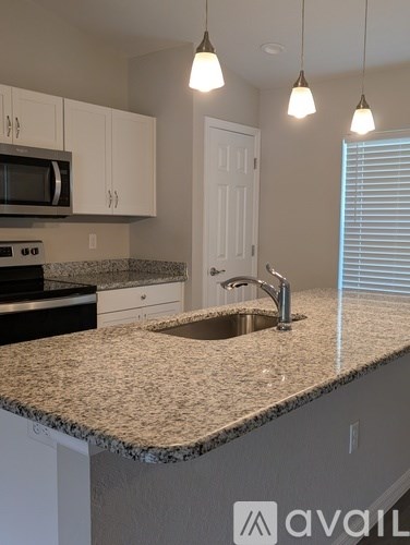 A kitchen with granite countertops and white cabinets.