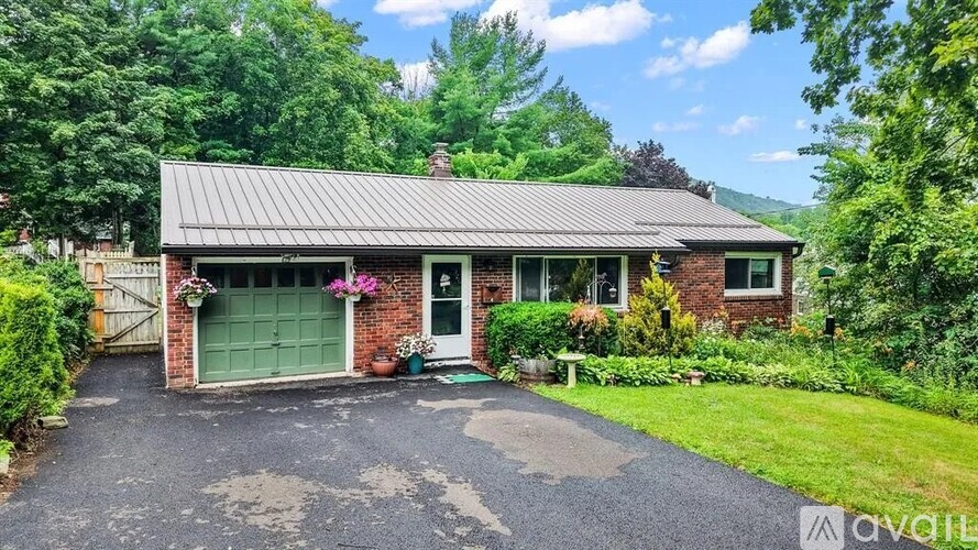 A house with a green door and a driveway in front.
