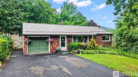 A house with a green door and a driveway in front.