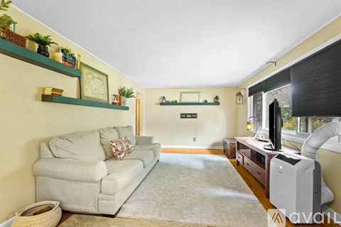 A living room with a grey couch and a white television.