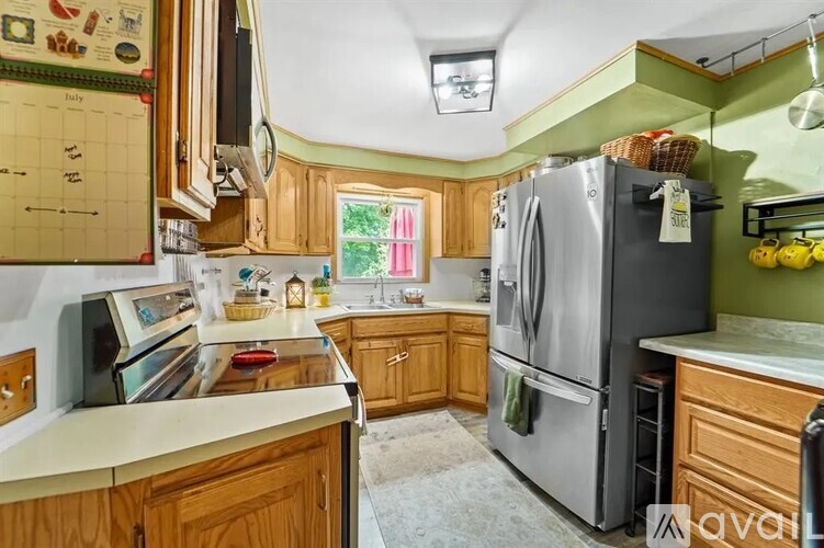 A kitchen with wooden cabinets and a large refrigerator.