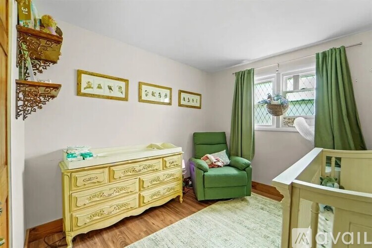A baby room with a yellow crib and a green chair.