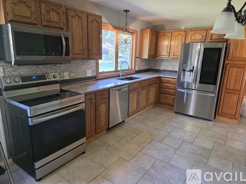 A kitchen with wooden cabinets and stainless steel appliances.