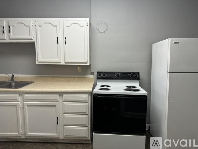 A kitchen with white cabinets and a black stove top oven.