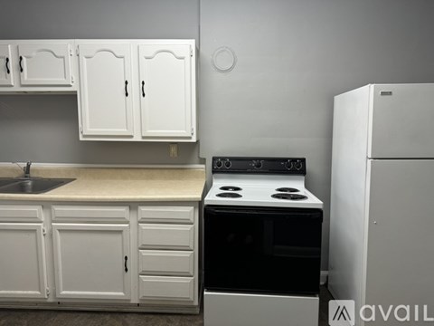 A kitchen with white cabinets and a black stove top oven.