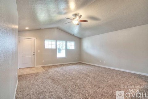 A room with a carpeted floor and a ceiling fan.