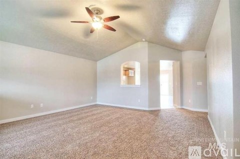 A room with a ceiling fan and carpeted floor.