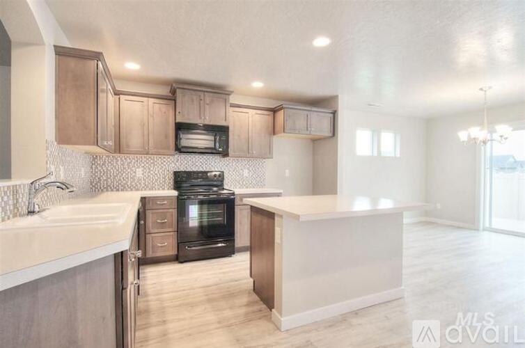 A kitchen with a black oven and wooden cabinets.