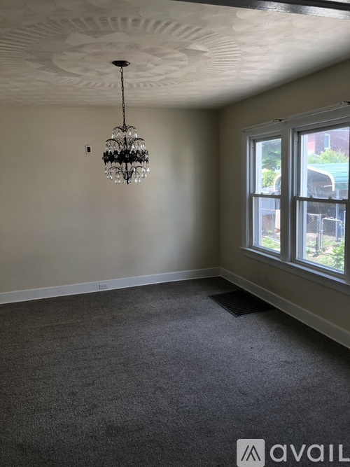 A room with a chandelier and a window.