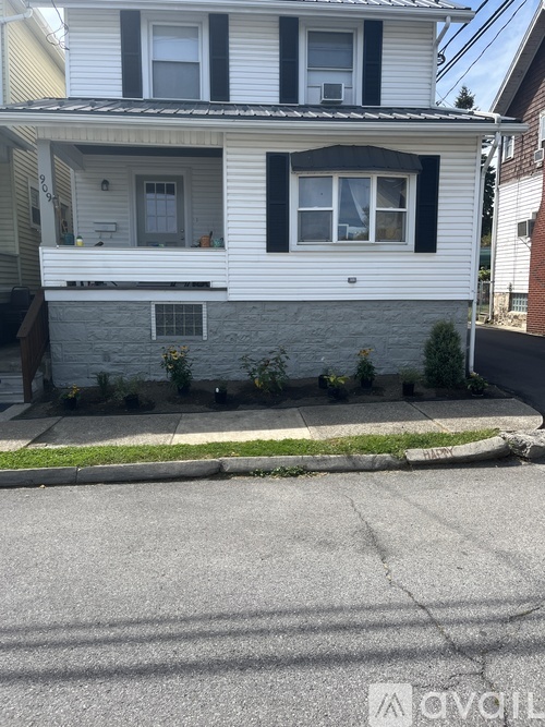 A two-story house with a white siding and black shutters.