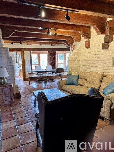 A living room with a couch, chairs, and a table.