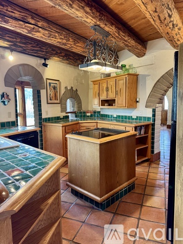 A kitchen with wooden cabinets and a green tile backsplash.