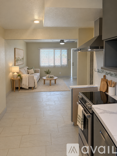 A modern kitchen with a large island and a living area in the background.