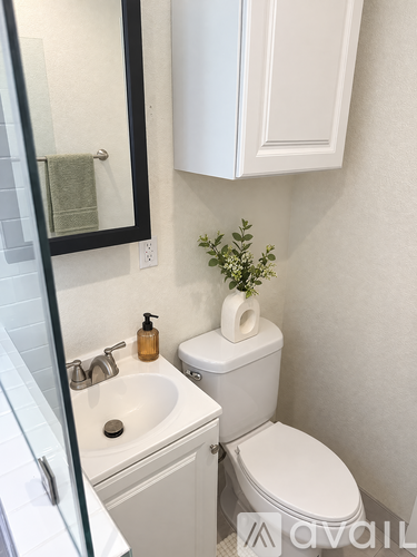 A white toilet sits next to a white sink in a bathroom.