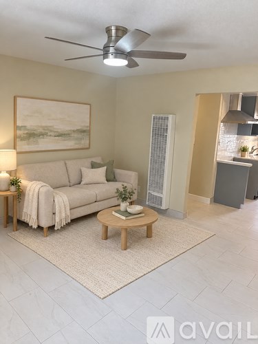 A living room with a couch, a coffee table, and a painting on the wall.