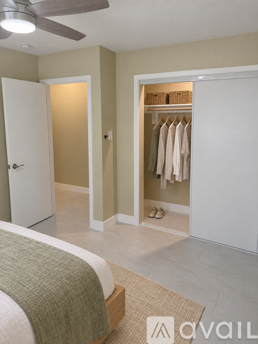 A bedroom with a bed, a closet, and a ceiling fan.