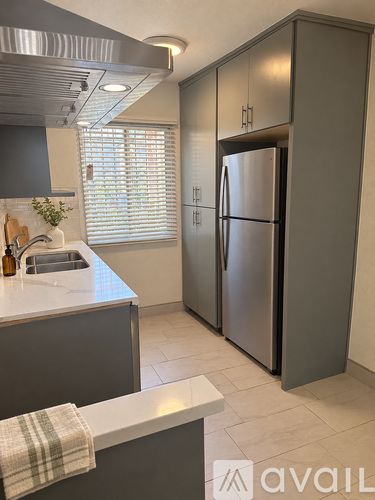 A kitchen with a refrigerator and a sink.