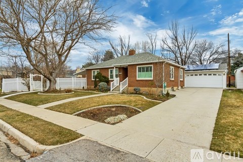 A house with a white fence and a green lawn.