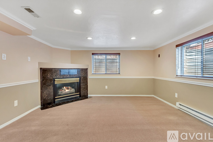 A living room with a fireplace and carpeted floor.