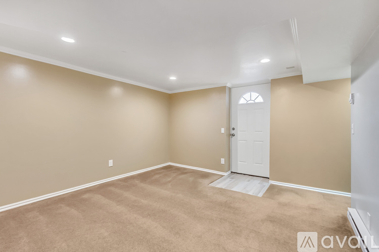 A room with a white door and carpeted floor.