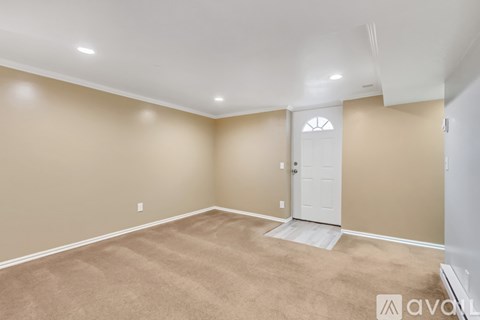 A room with a white door and carpeted floor.