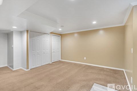 A room with a carpeted floor and a white ceiling with lights.