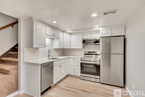 A kitchen with white cabinets and stainless steel appliances.