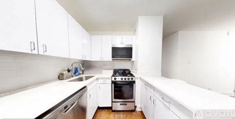 A kitchen with white cabinets and a stove top oven.
