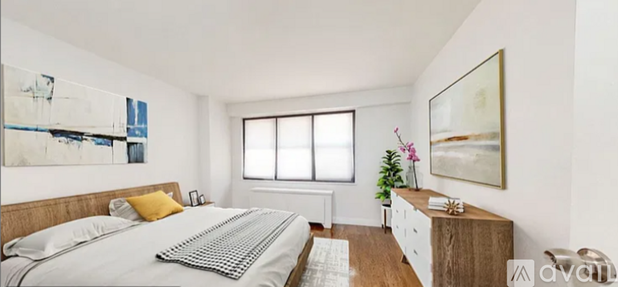 A bedroom with a large bed and a painting on the wall.