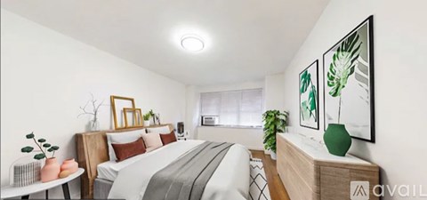 A bedroom with a bed, nightstand, and a plant.