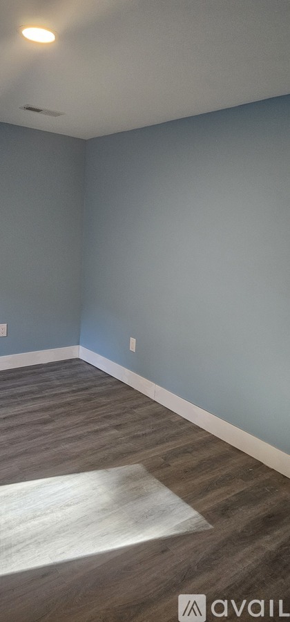 A room with a light blue wall and a wooden floor.