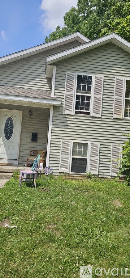 A house with a grey siding and a white door.