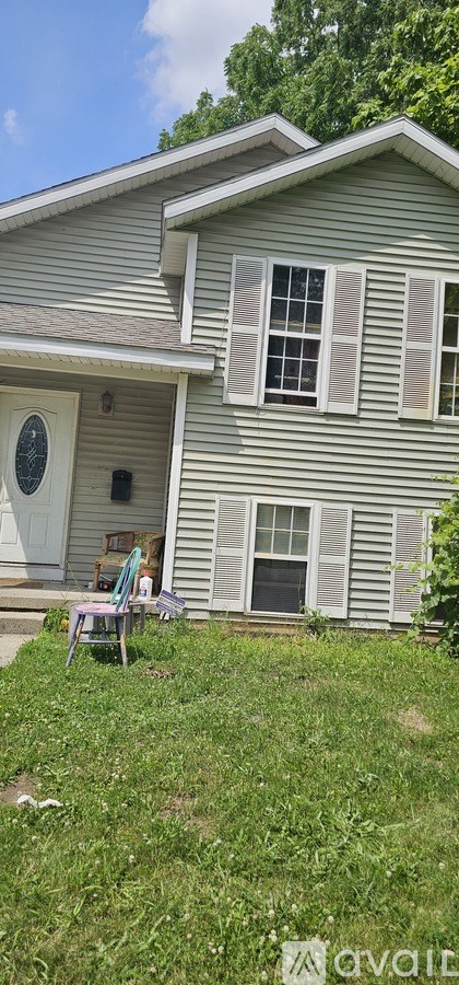 A house with a grey siding and a white door.