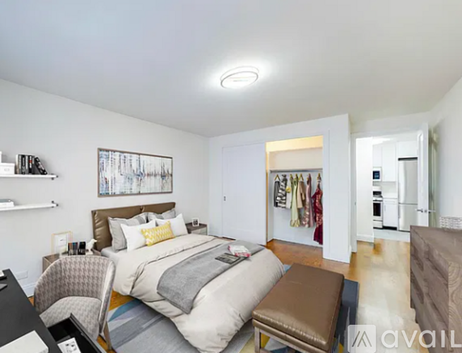 A bedroom with a bed, chair, and a painting on the wall.
