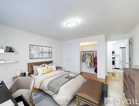 A bedroom with a bed, chair, and a painting on the wall.