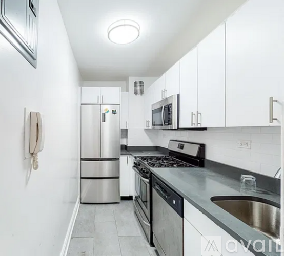 A kitchen with white cabinets and stainless steel appliances.