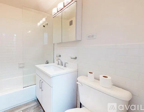 A white bathroom with a toilet, sink, and mirror.