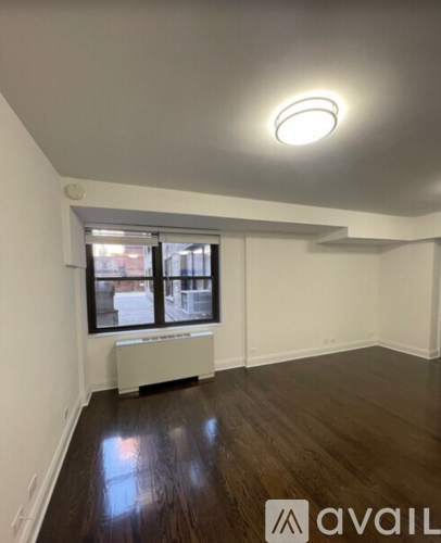 A room with a window and a radiator on the floor.